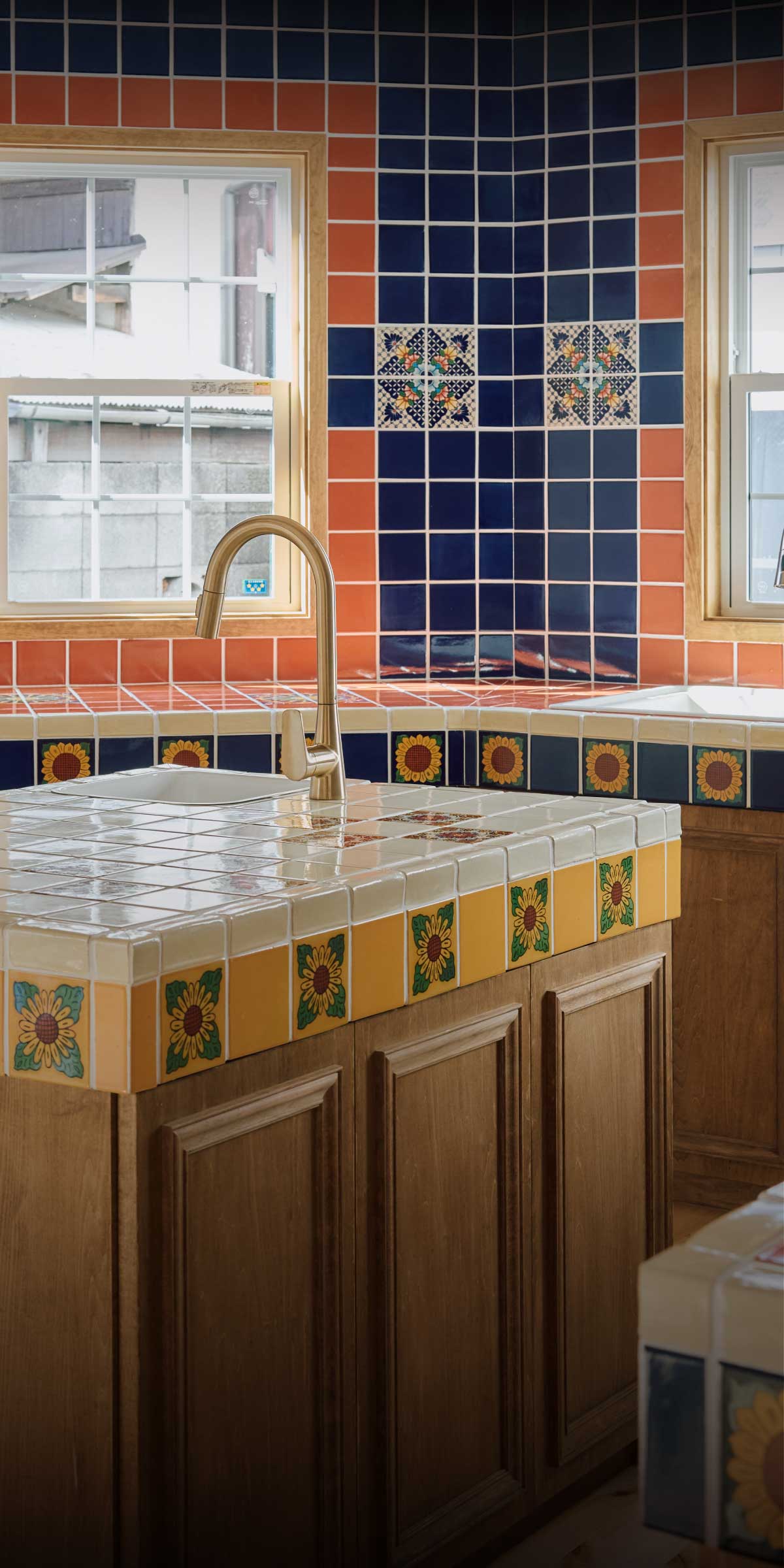 横浜の工務店による注文住宅：タイル張りの壁と木製家具が特徴的なおしゃれなキッチン