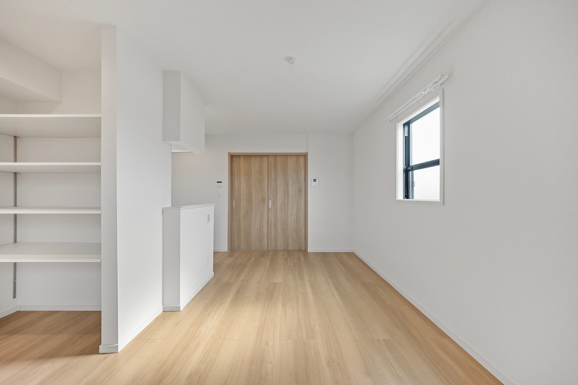 横浜の工務店による敷地をフル活用。個性豊かな空間設計が魅力的なアパート：LDKから居室のドアを閉じた景色