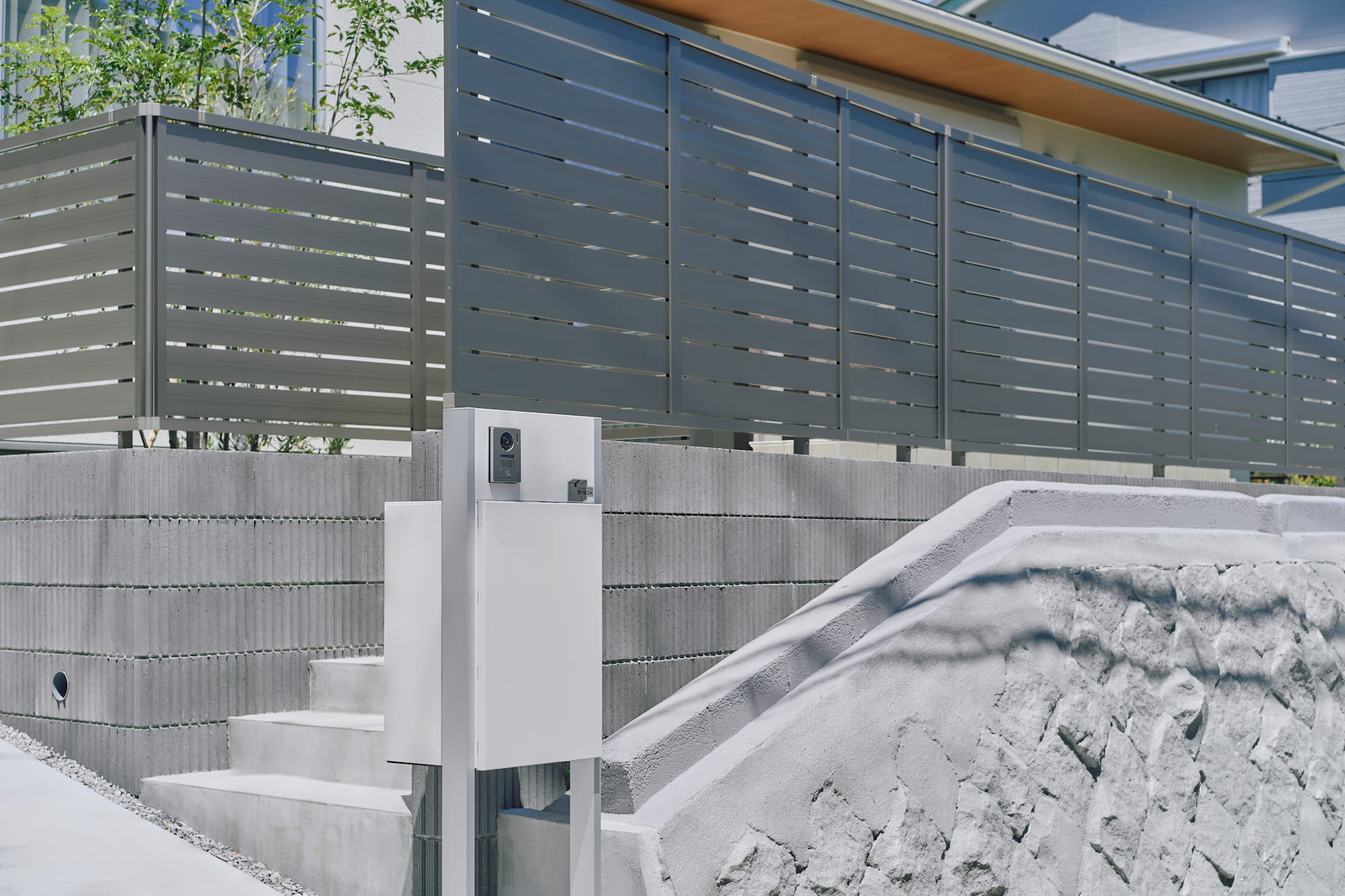 横浜の工務店による自然光を活用して心地よい日常を形にする、白い外観の住まい：お施主様自らが表面のテクスチャを表現された擁壁