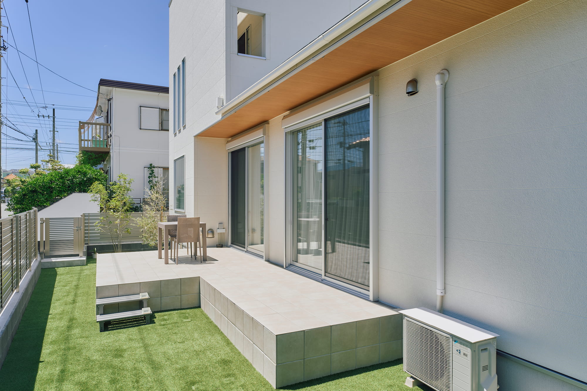 横浜の工務店による自然光を活用して心地よい日常を形にする、白い外観の住まい：軒下には温もりを感じさせる木の質感をプラス