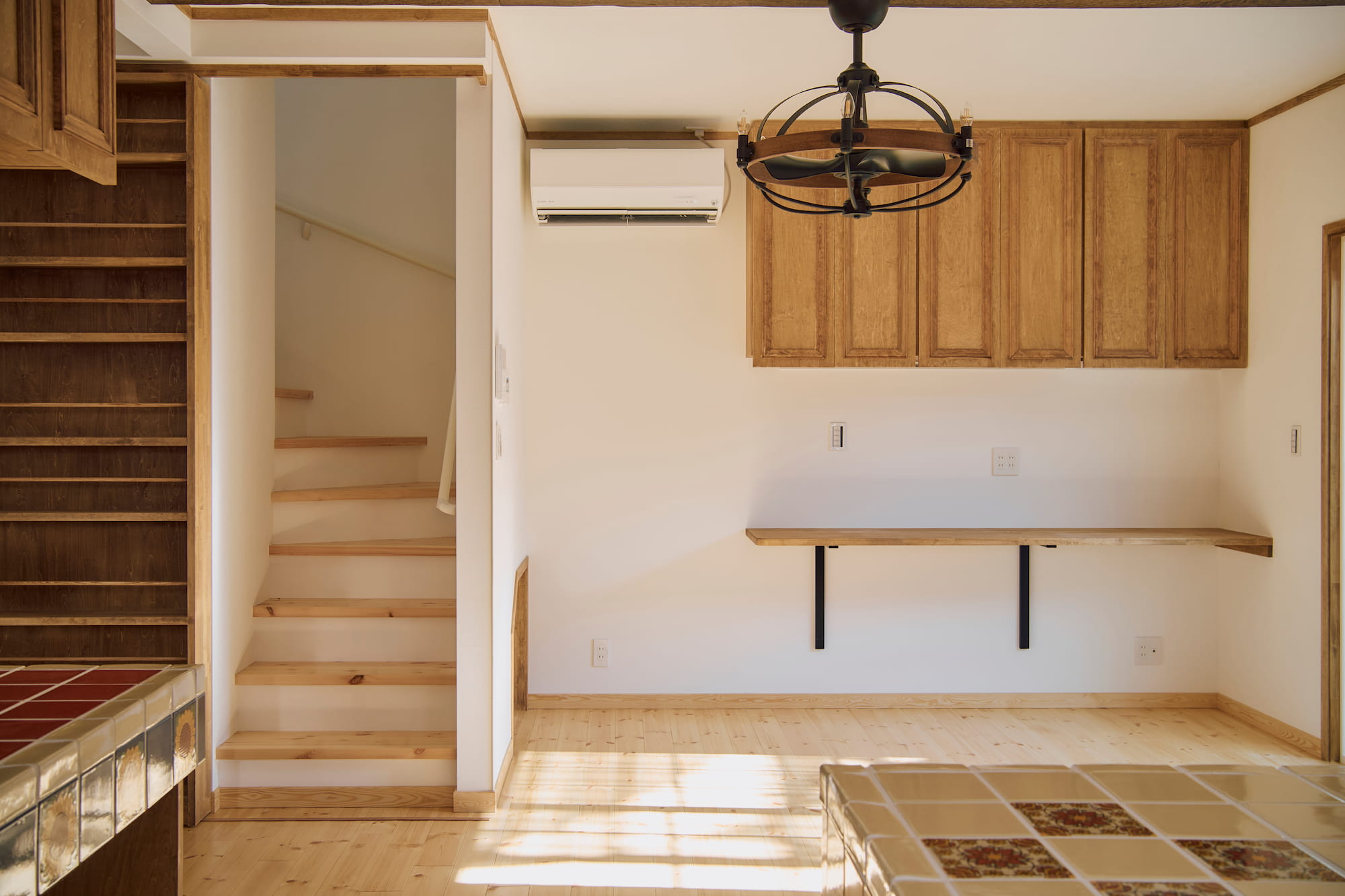 横浜の工務店による異国の風を纏う、一生ものの邸宅：本棚の隠し扉が開かれ階段が伺える室内