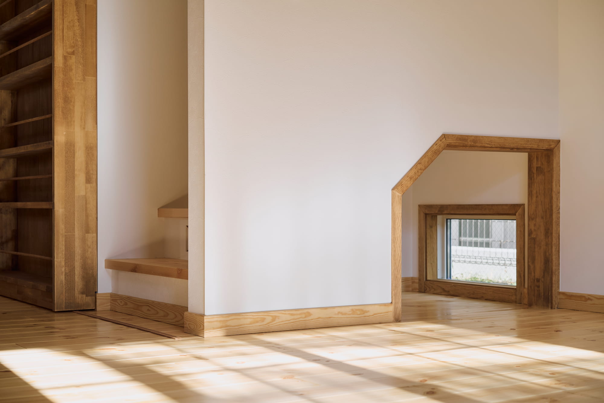 横浜の工務店による異国の風を纏う、一生ものの邸宅：ペットのための小窓がある階段下のスペース