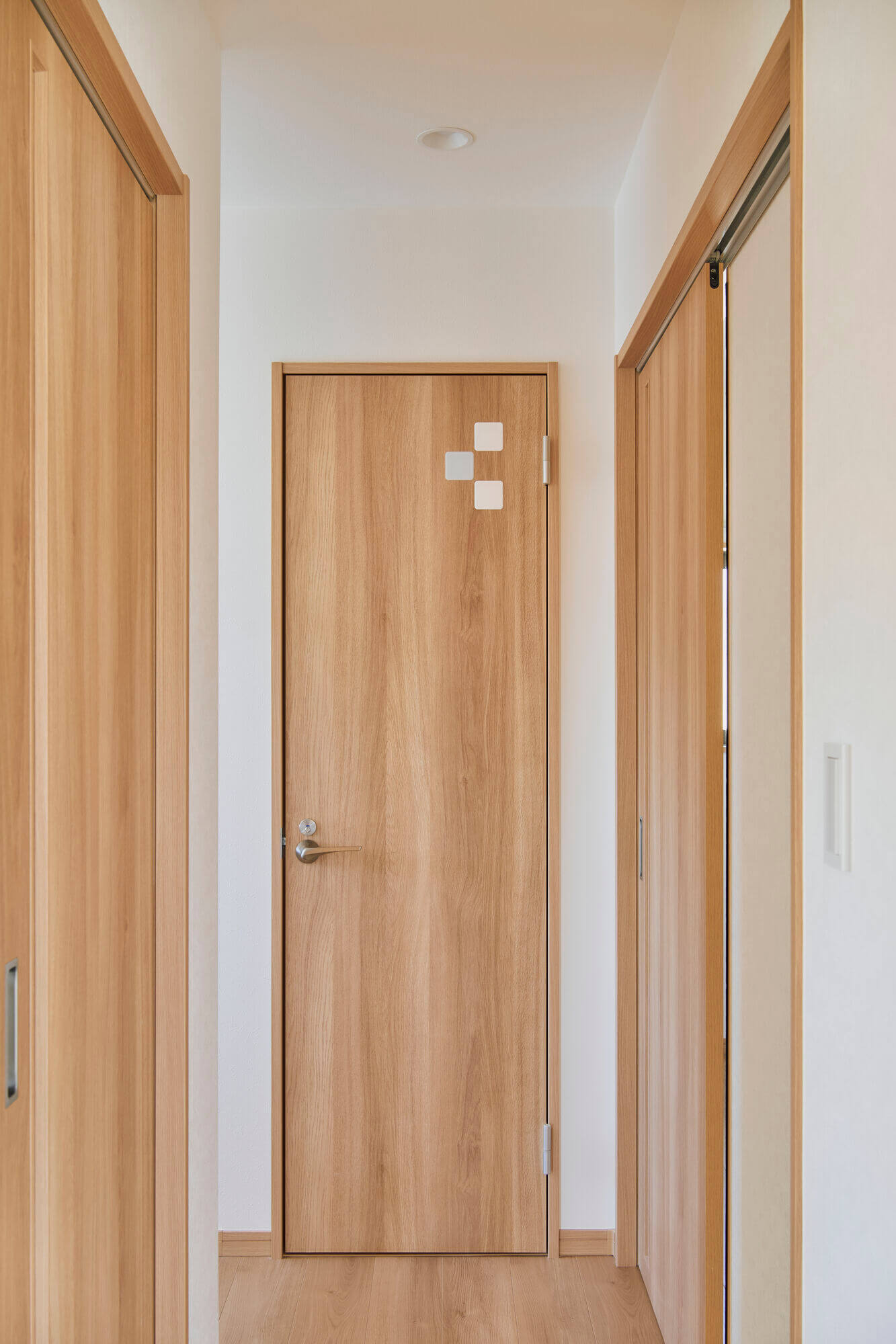 横浜の工務店によるより安全で安心の住み心地を目指した住宅のリノベーション：木目ドアの廊下空間