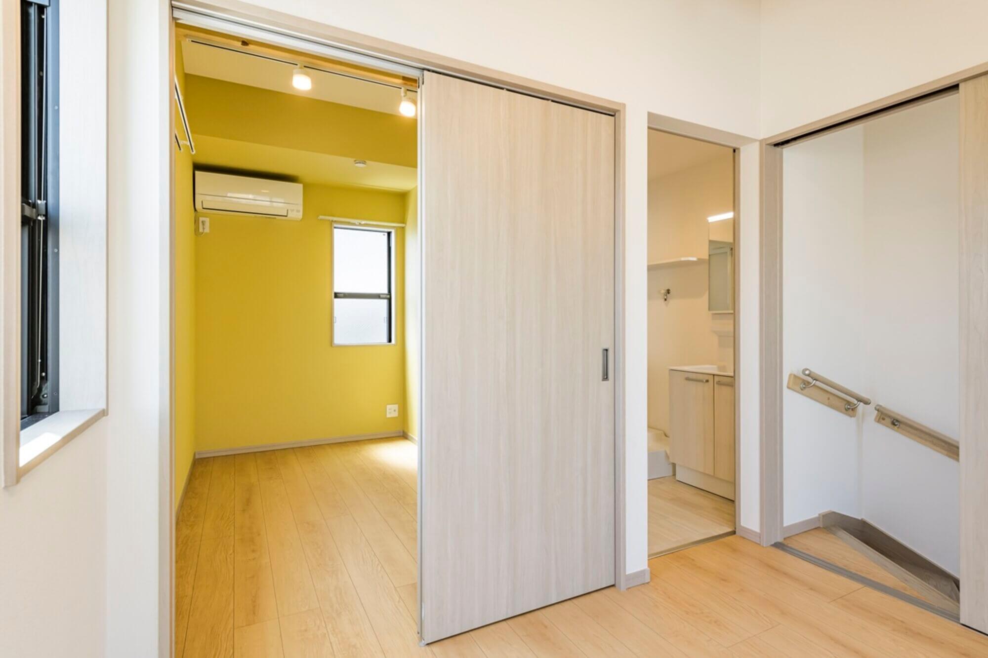 横浜の工務店による個性あるお部屋が詰め込まれた、遊び心あるアパート。：黄色のアクセント壁の個室